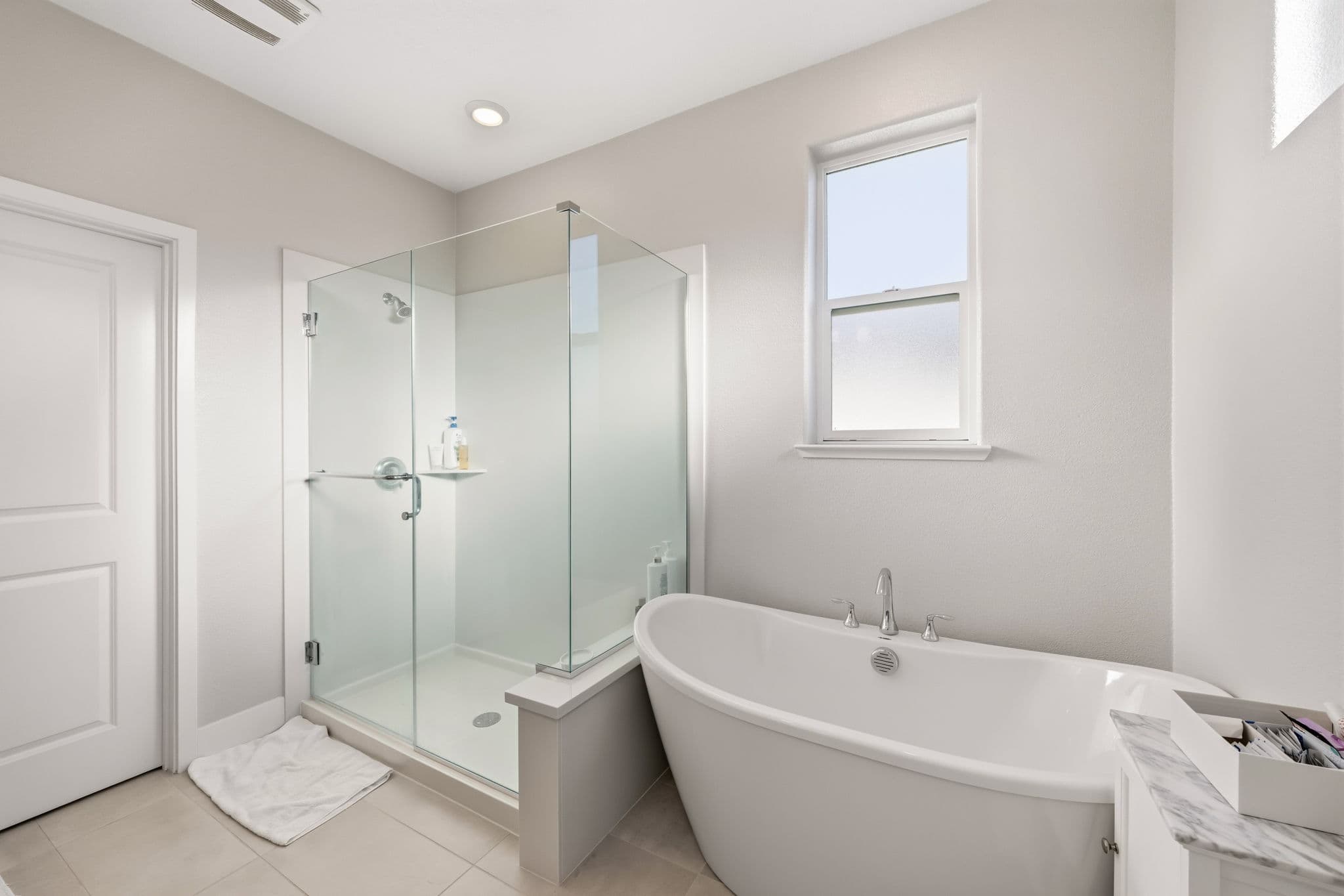 Owner's spa bath — freestanding soaking tub and frameless-glass walk-in shower