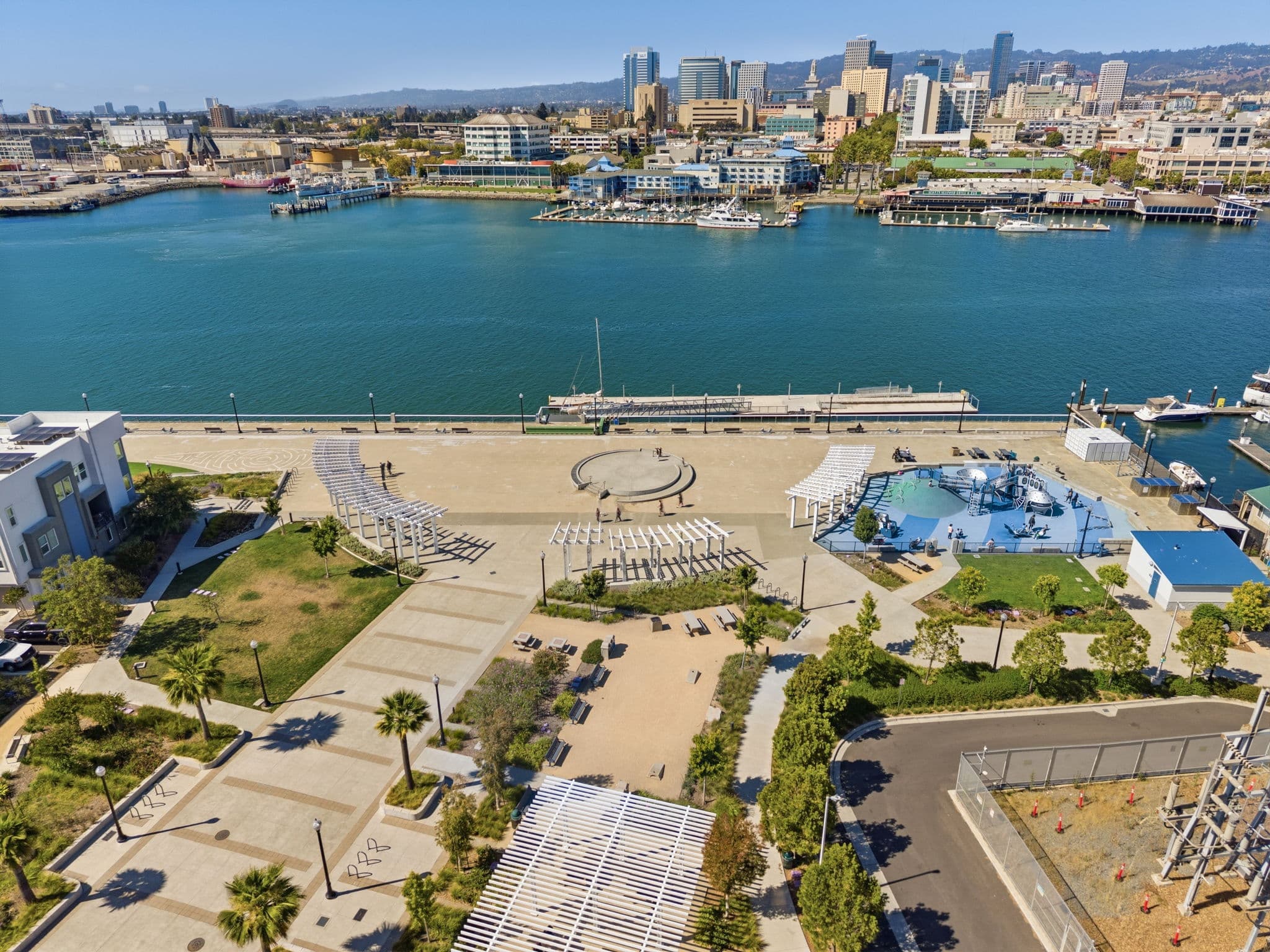 Waterfront promenade with the Oakland skyline across the estuary