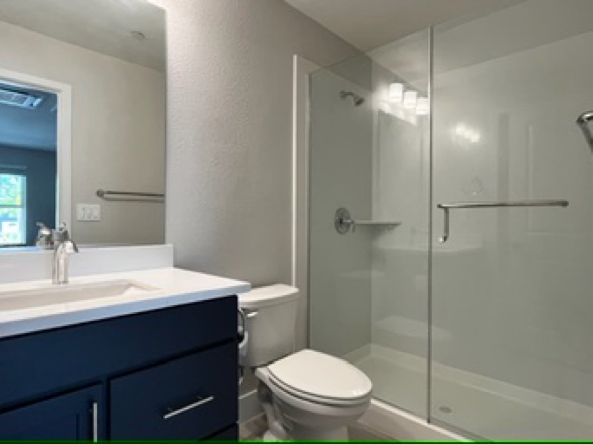 Full bathroom with navy vanity and glass shower